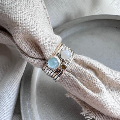 An Aquamarine, Moonstone and citrine ring group together with some stacking rings