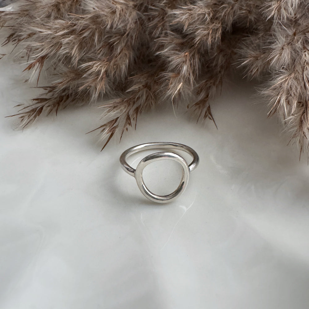 Silver Circle ring on a light background with dried pampas grass