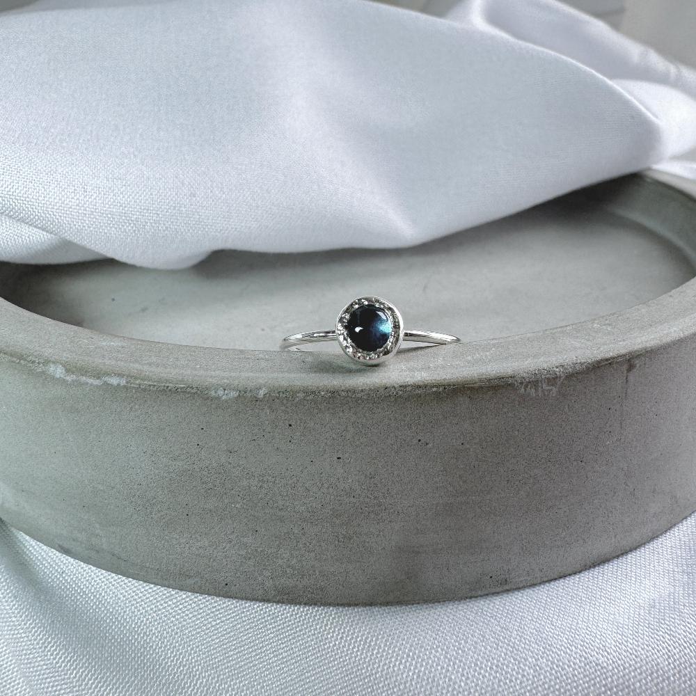 A blue topaz stone set in silver on a delicate silver band