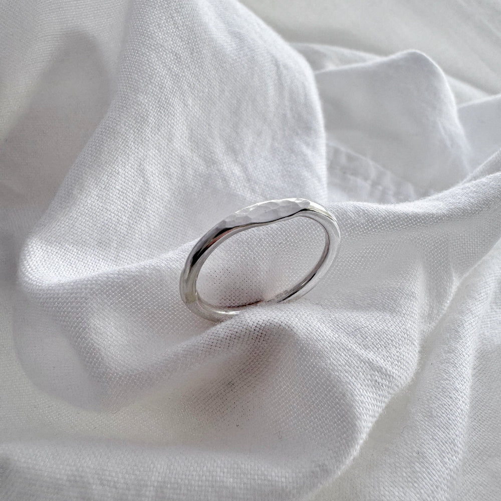silver hammered mini signet ring on a white fabric 