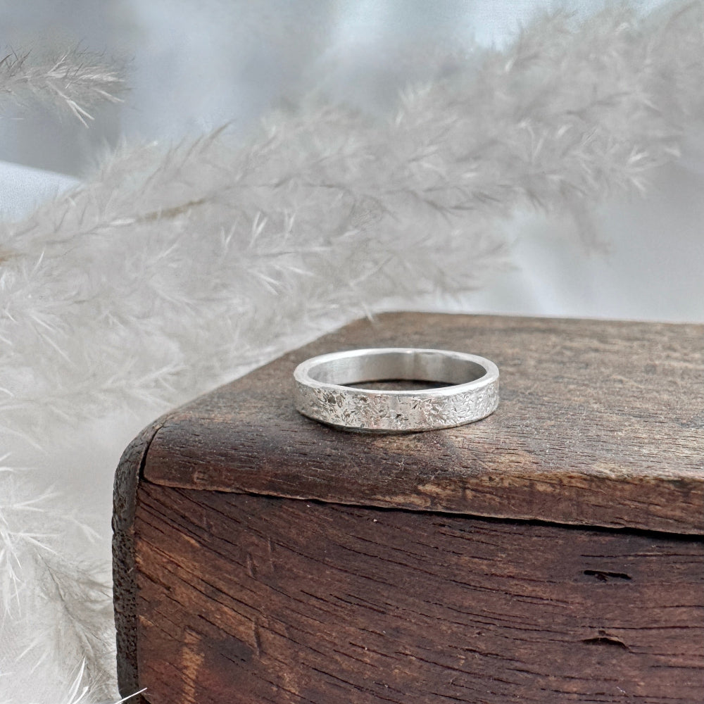 Silver ring on a wooden box with a soft, blurred background