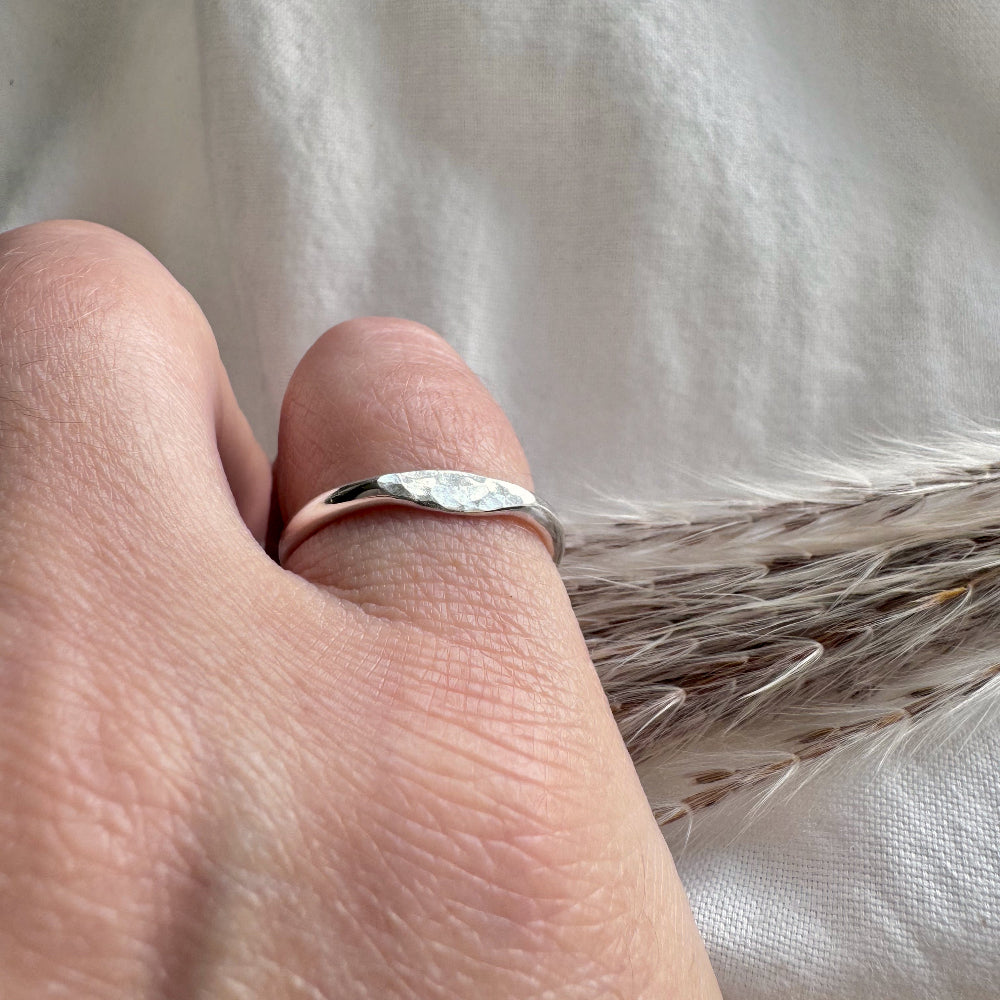 silver hammered mini signet ring worn on a little finger  