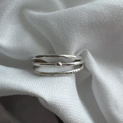 Silver ring on a textured white fabric background