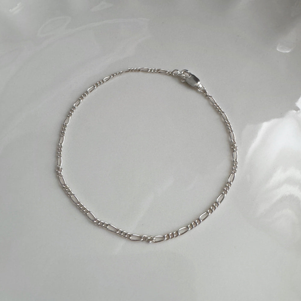 Silver bracelet on a white ceramic plate