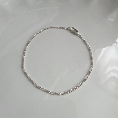 Silver bracelet on a white ceramic plate