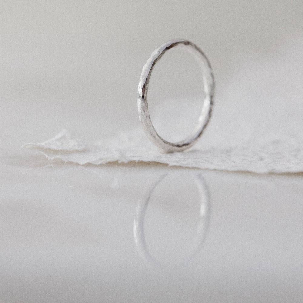 A Silver Ring with a hammered texture on a white background