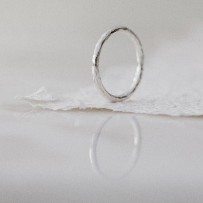 A Silver Ring with a hammered texture on a white background