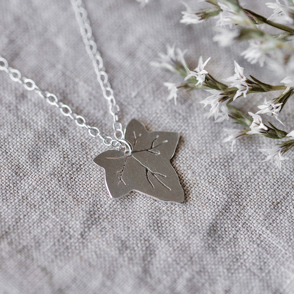 A silver necklace featuring a Ivy leaf-shaped pendant, displayed against a neutral background 
