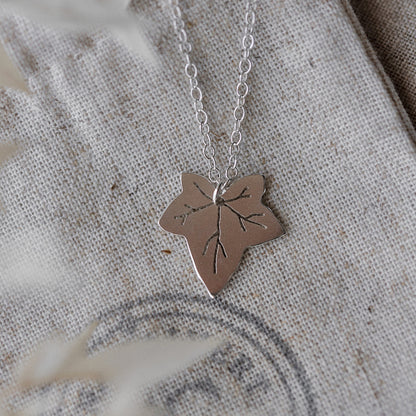 A silver necklace featuring a Ivy leaf-shaped pendant, displayed against a neutral background 