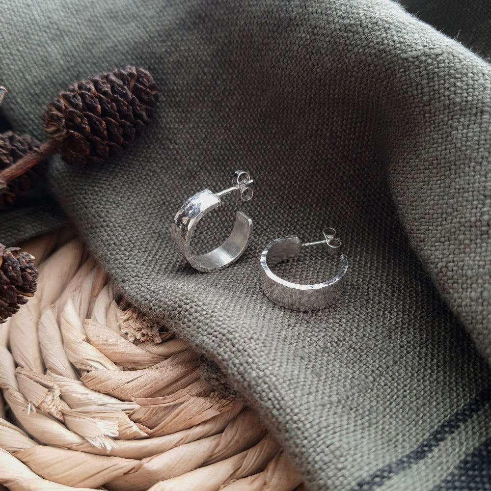 Chunky 6mm wide Silver Hoops Earrings with a hammered finish on a green fabric 