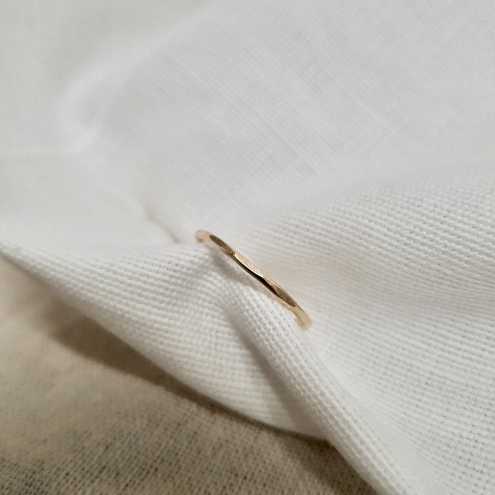 A 9ct gold hexagonal stacking ring on a cream textured fabric