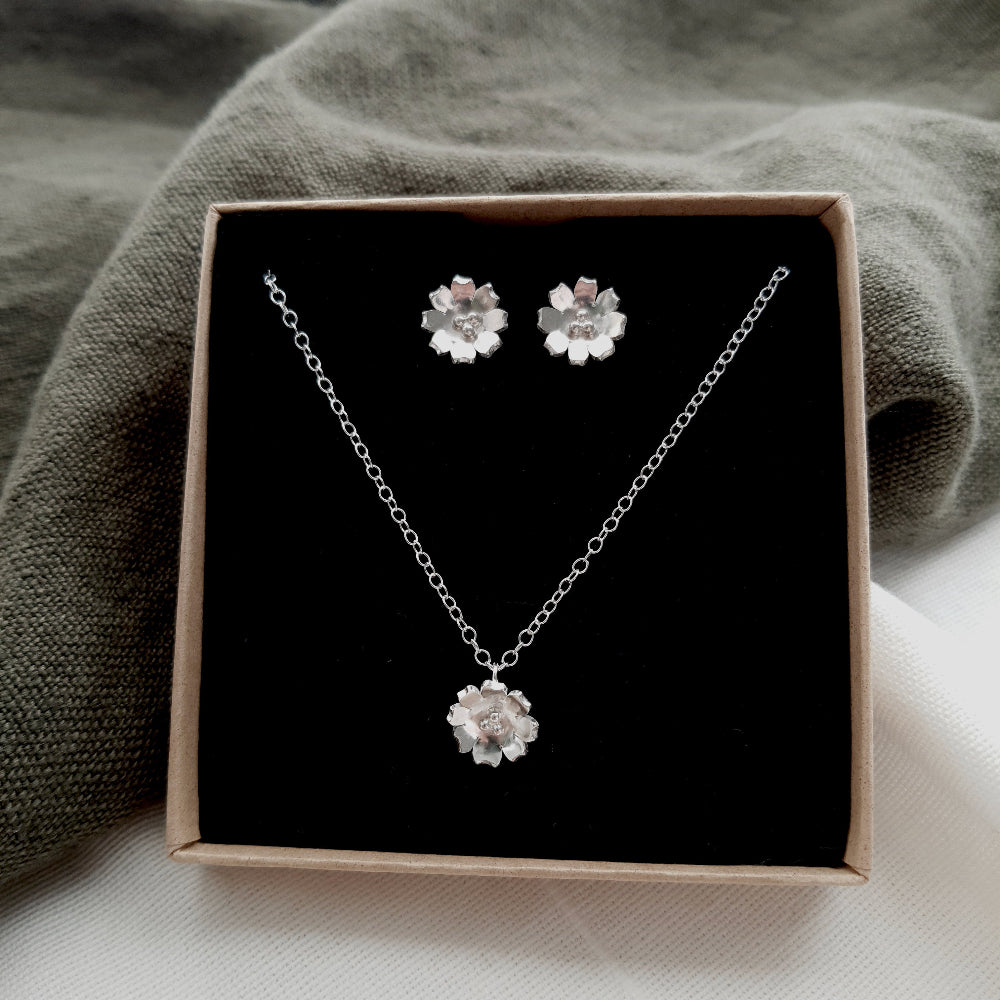 sliver flower earrings and necklace presented in a box with a black insert