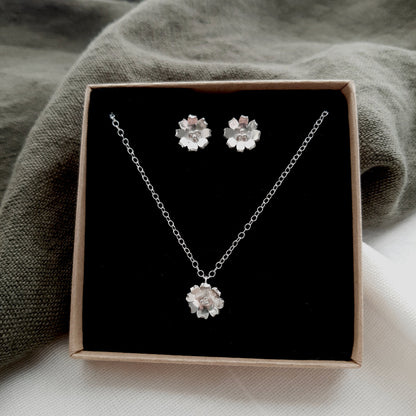 sliver flower earrings and necklace presented in a box with a black insert