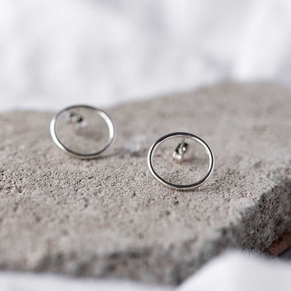 Large Circle Silver Studs Earrings on a natural stone background