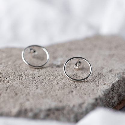 Large Circle Silver Studs Earrings on a natural stone background