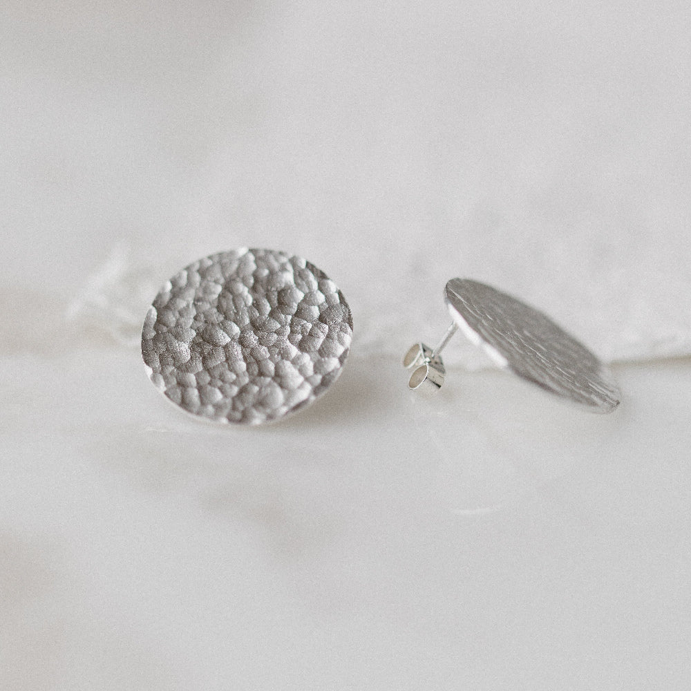 A pair of large silver hammered disc earrings 