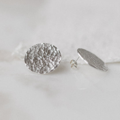 A pair of large silver hammered disc earrings 